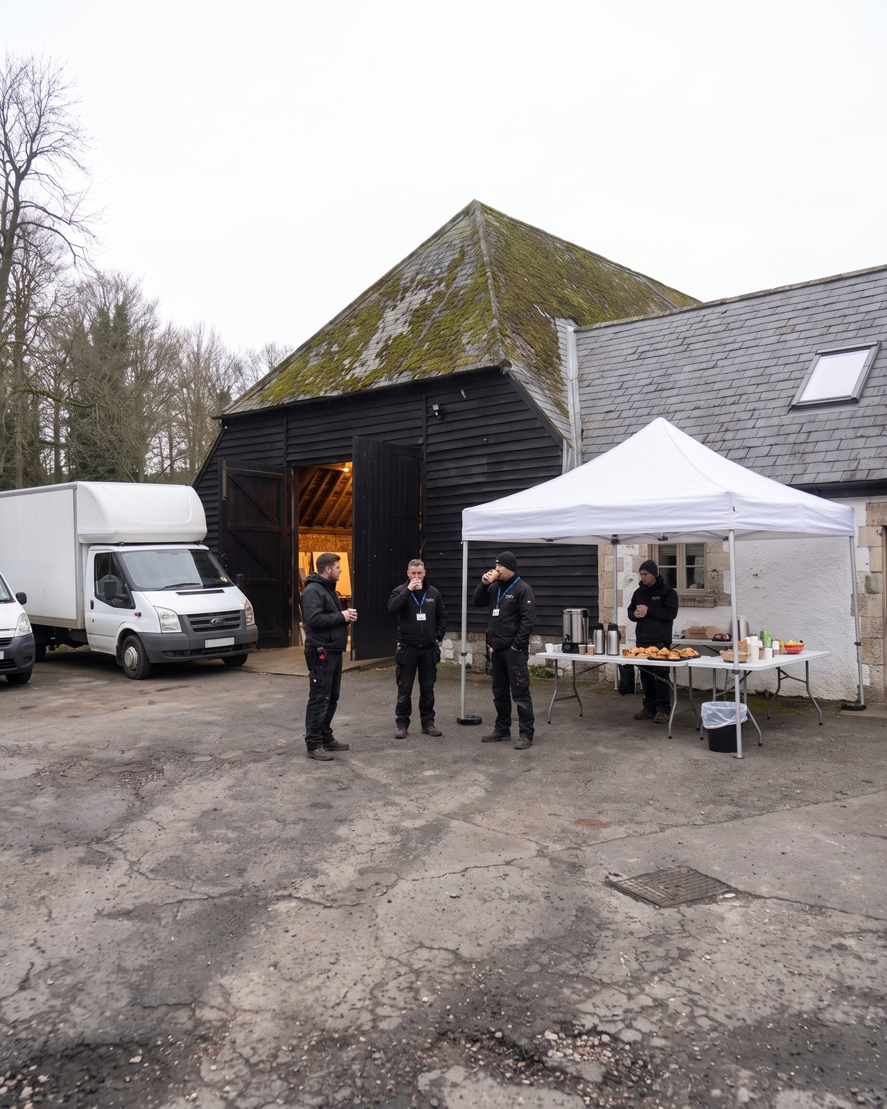 Crew around the catering gazebo beside the office wall