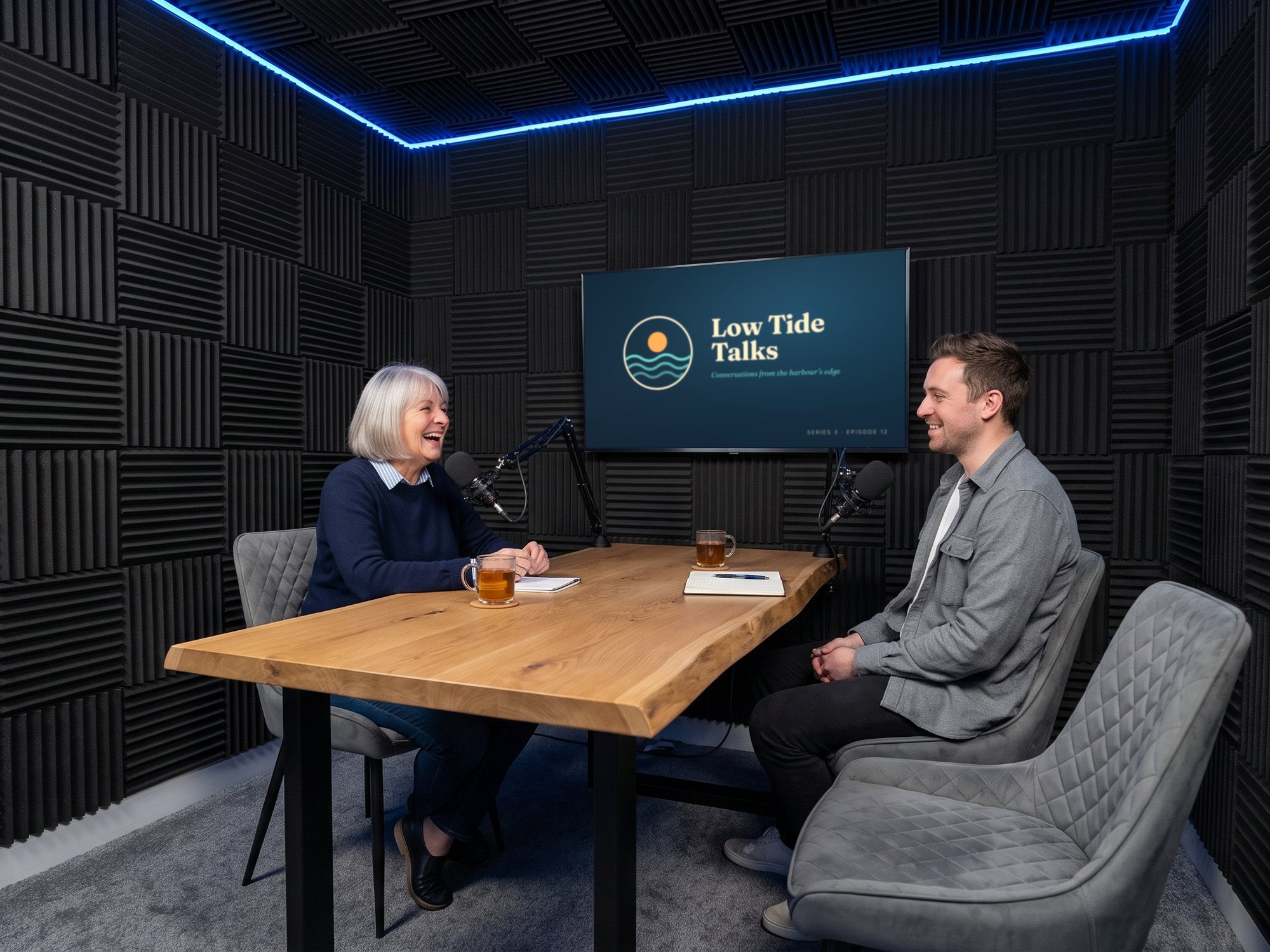 A podcast recording at the live-edge table, the show's title card on the wall screen