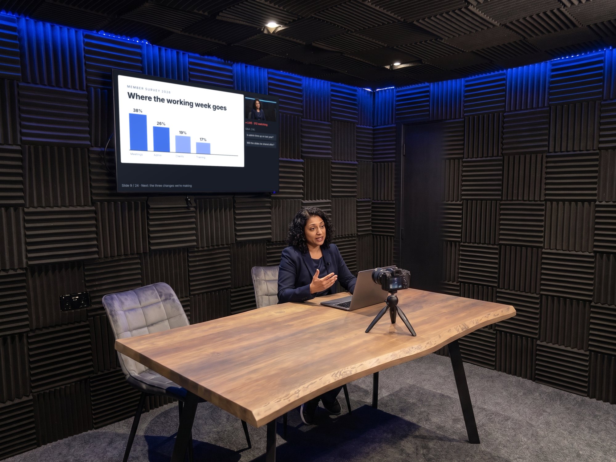 A presenter delivering a webinar from the studio, her slides on the wall screen