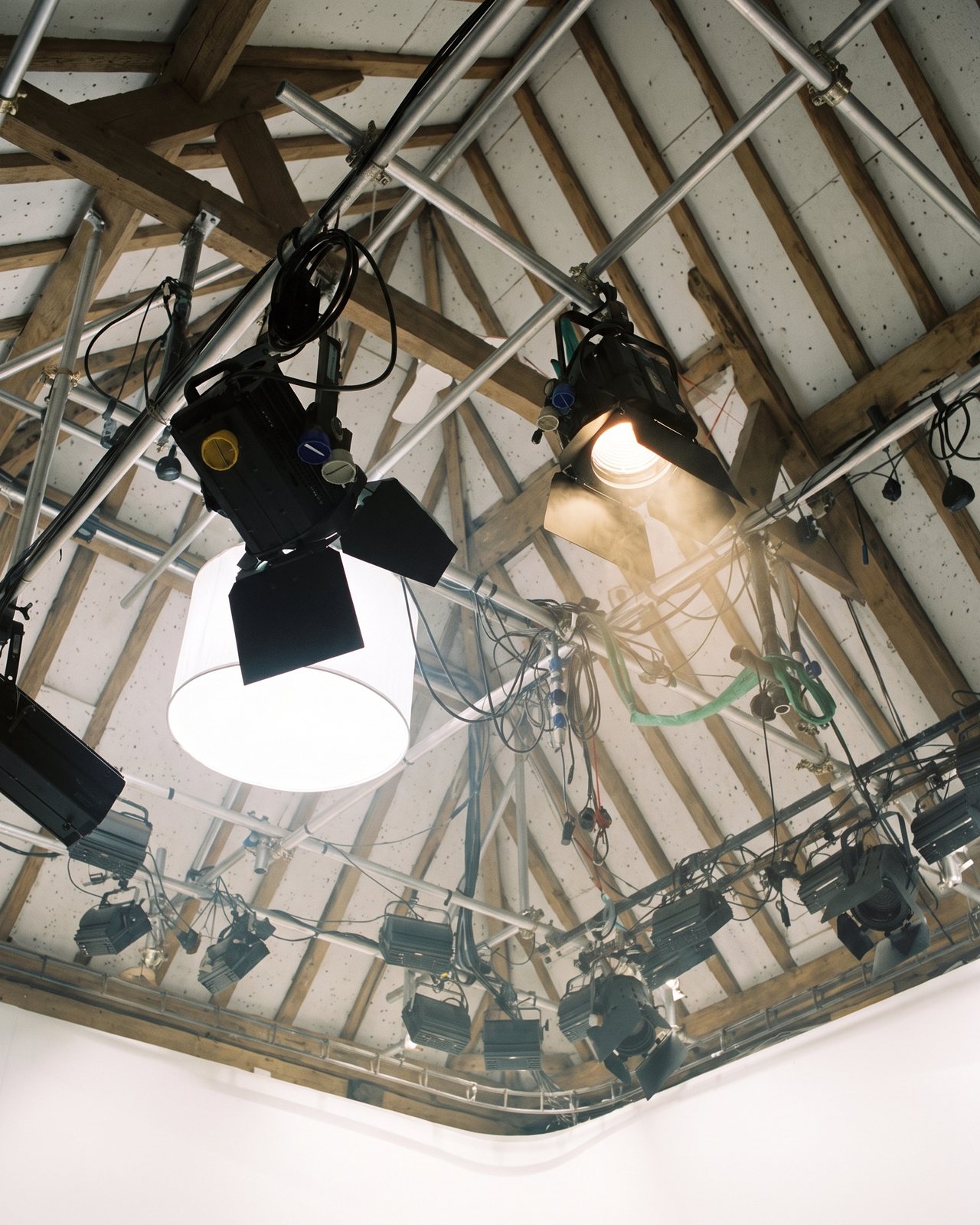 Looking up at the lighting grid and the oak roof through haze