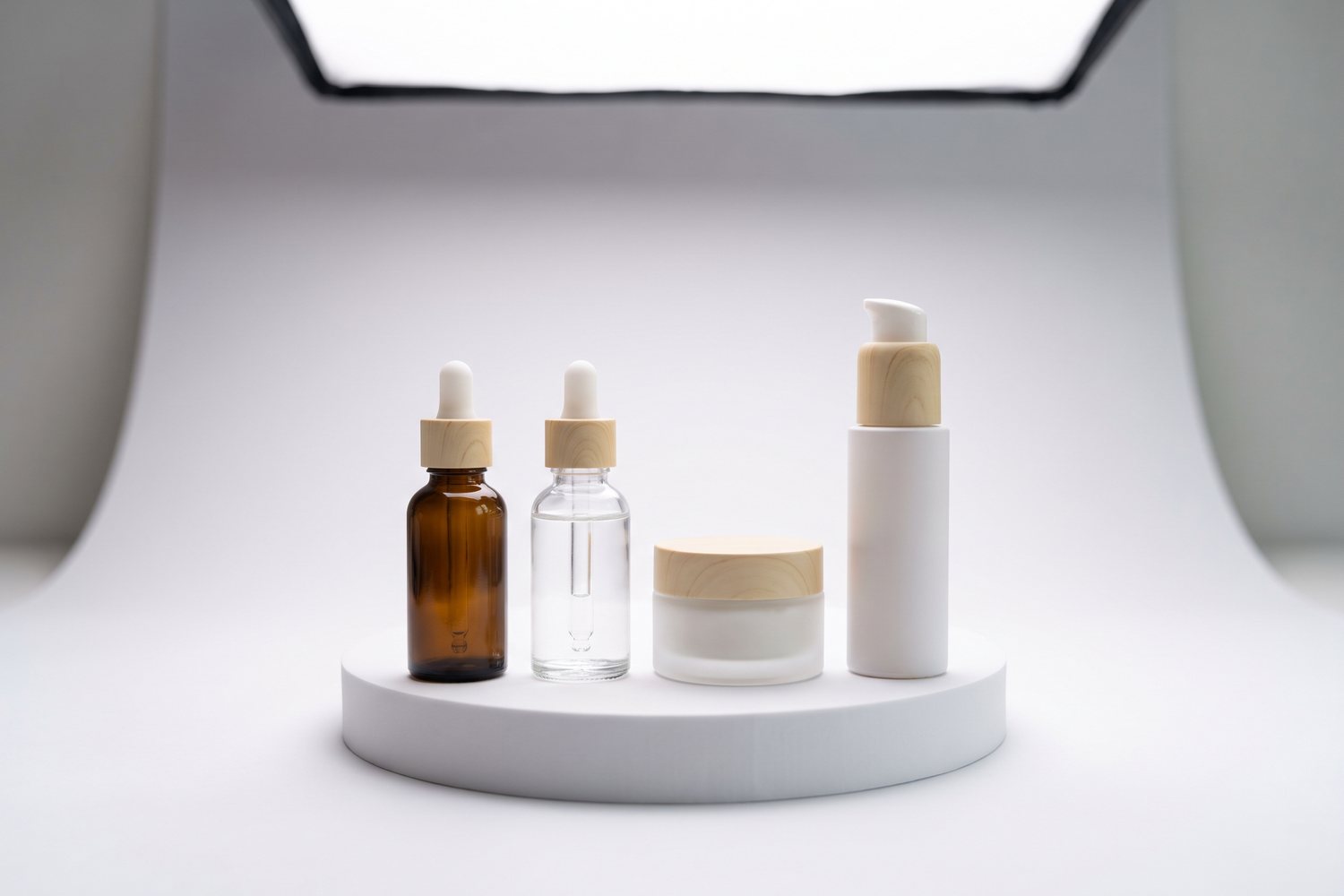 Skincare bottles on a white plinth on the cove