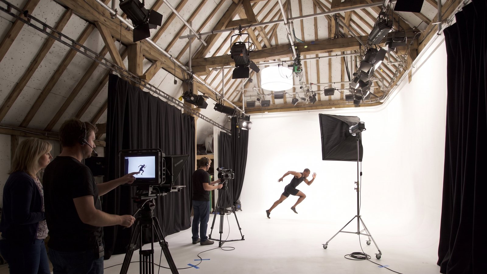 A sprinter crossing the cove while the director watches the monitor