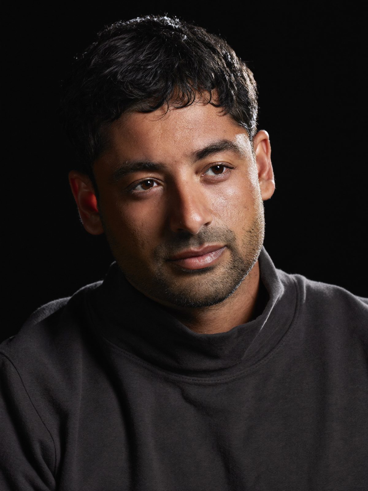Example low-key portrait, a man in a dark roll-neck on a near-black background