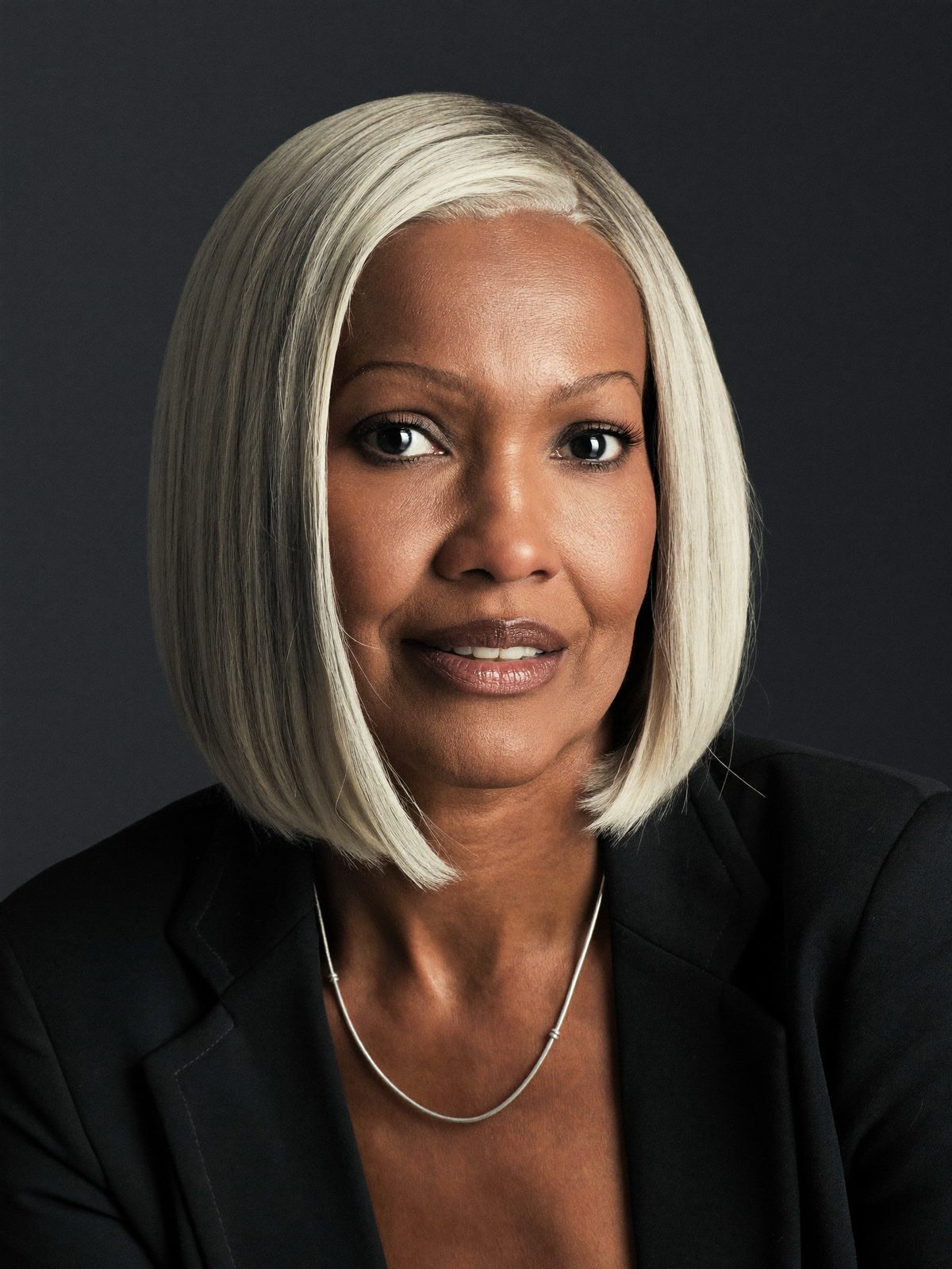 Example executive headshot, a woman with a silver bob on a dark background