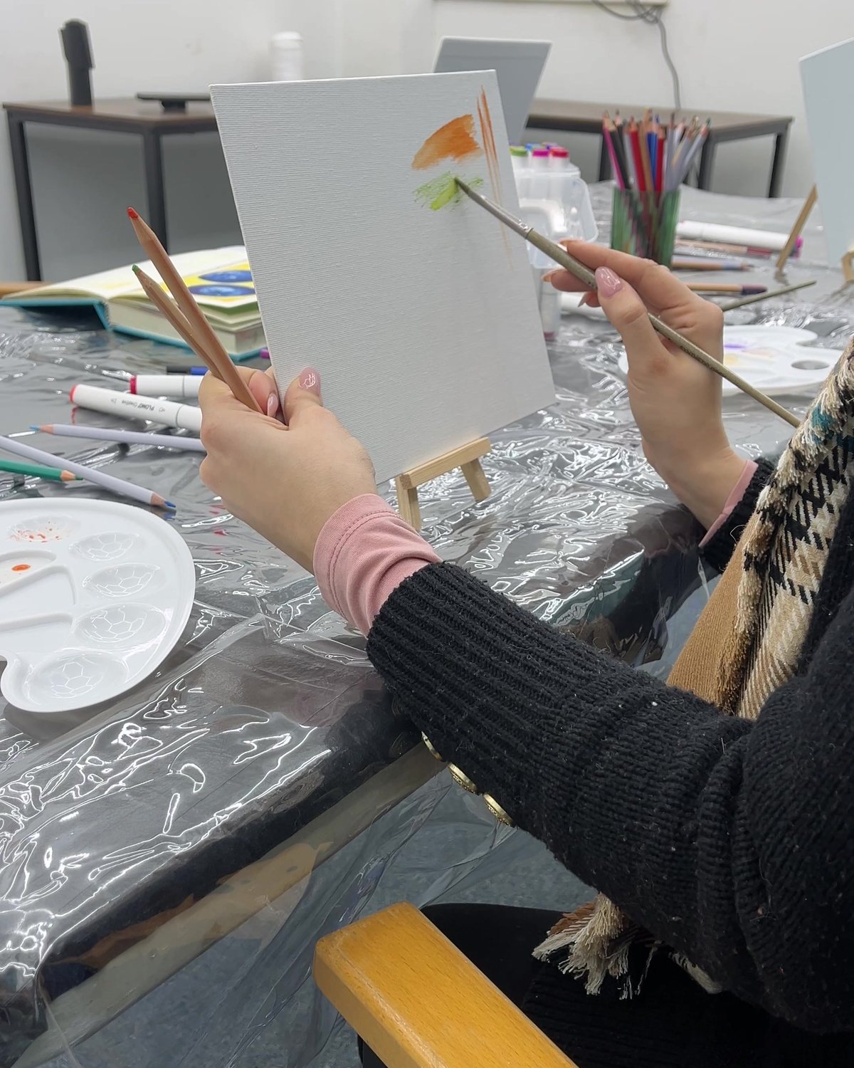Painting a canvas on a table easel during a workshop in the Grain Hopper