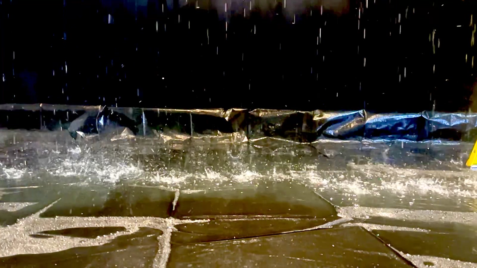 Rain falling into standing water on the studio deck