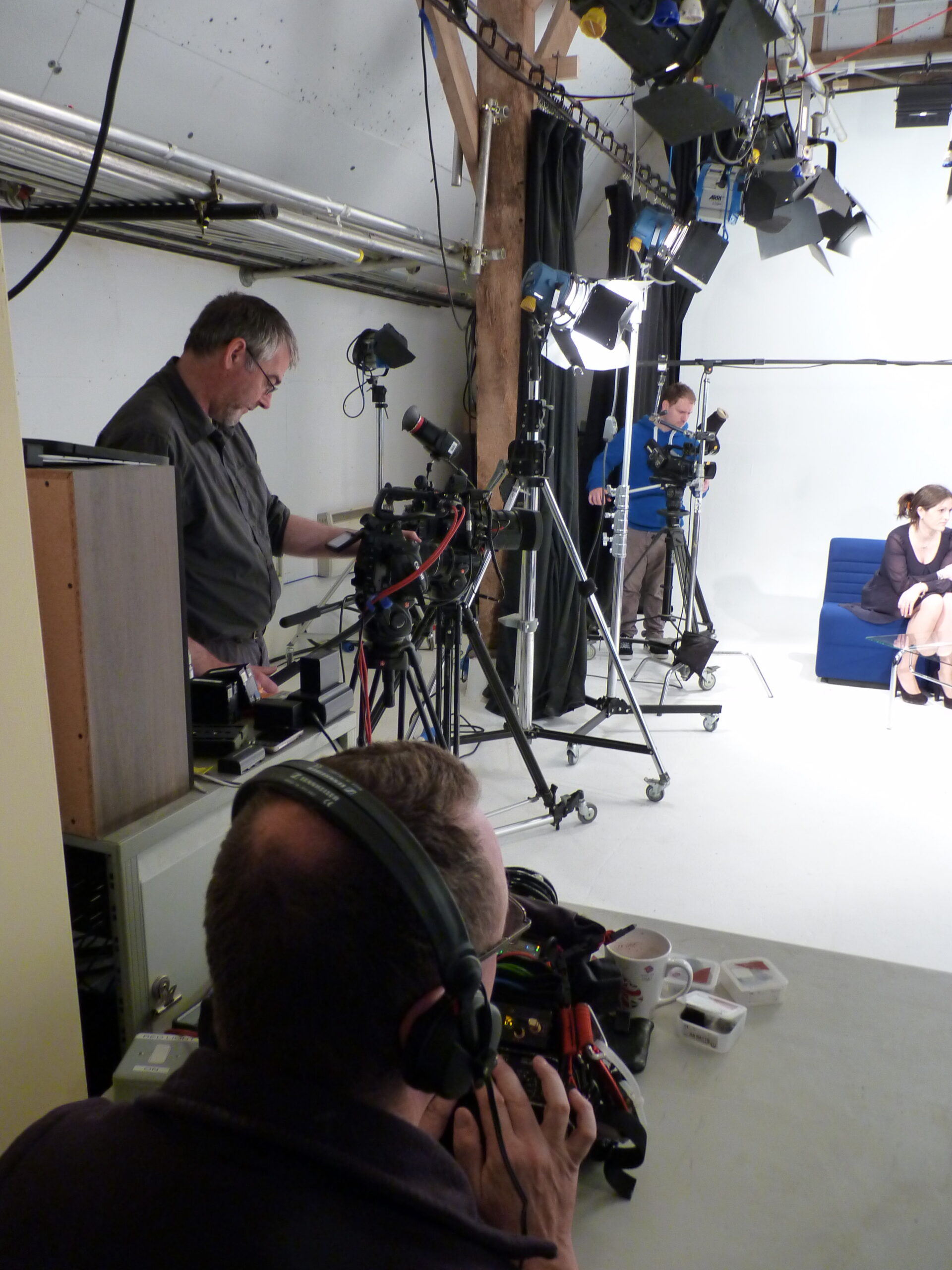 Man with camera equipment looking onto set