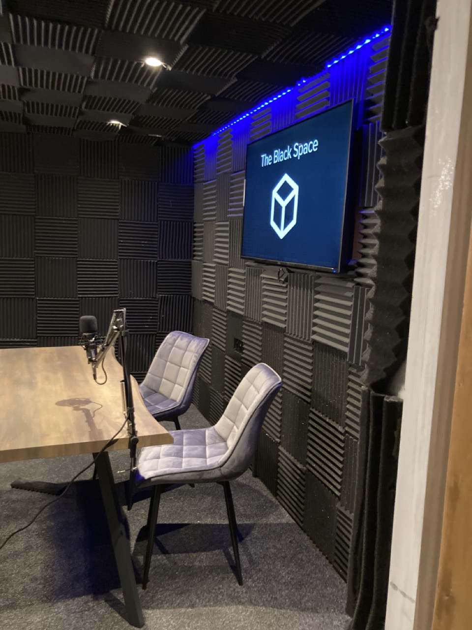 The Black Space with table, chairs, microphone and LED screen