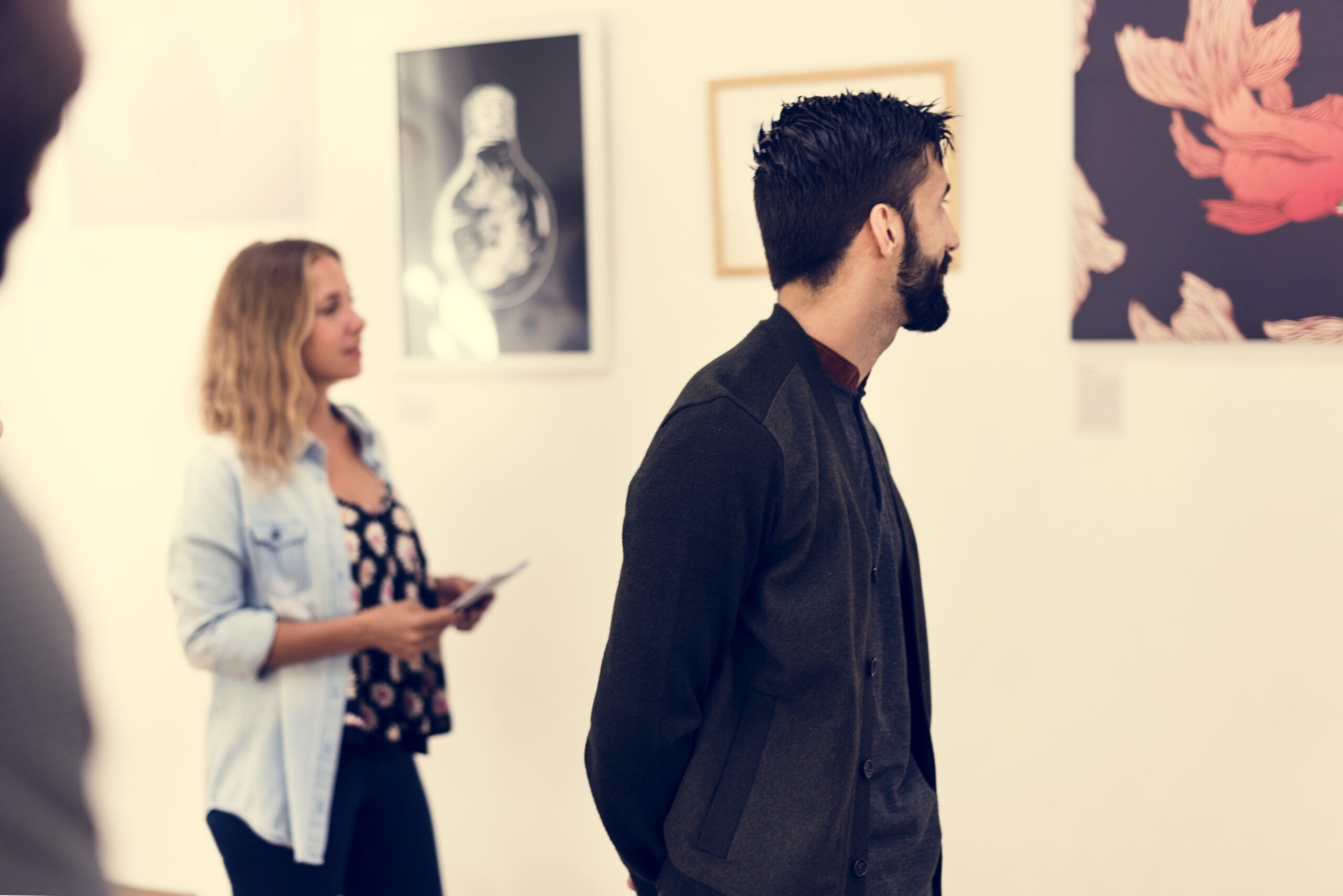 People looking at frames in exhibition People looking at images at an exhibition